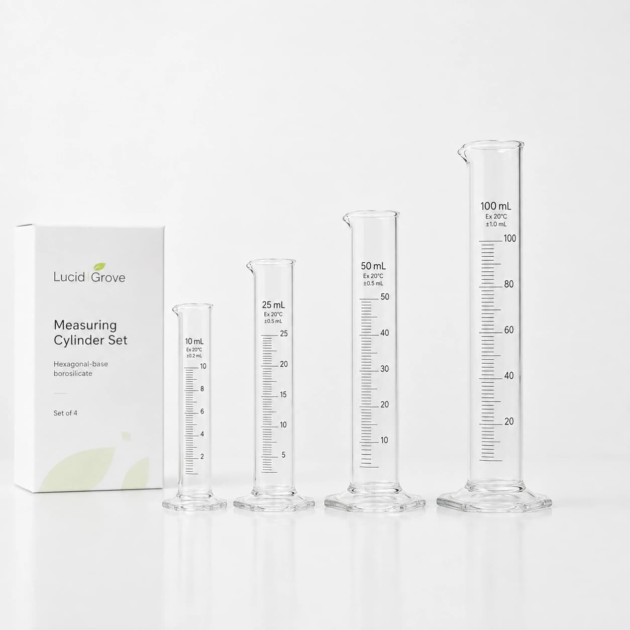A Lucid Grove set of four graduated borosilicate measuring cylinders with hexagonal bases, beside the box.