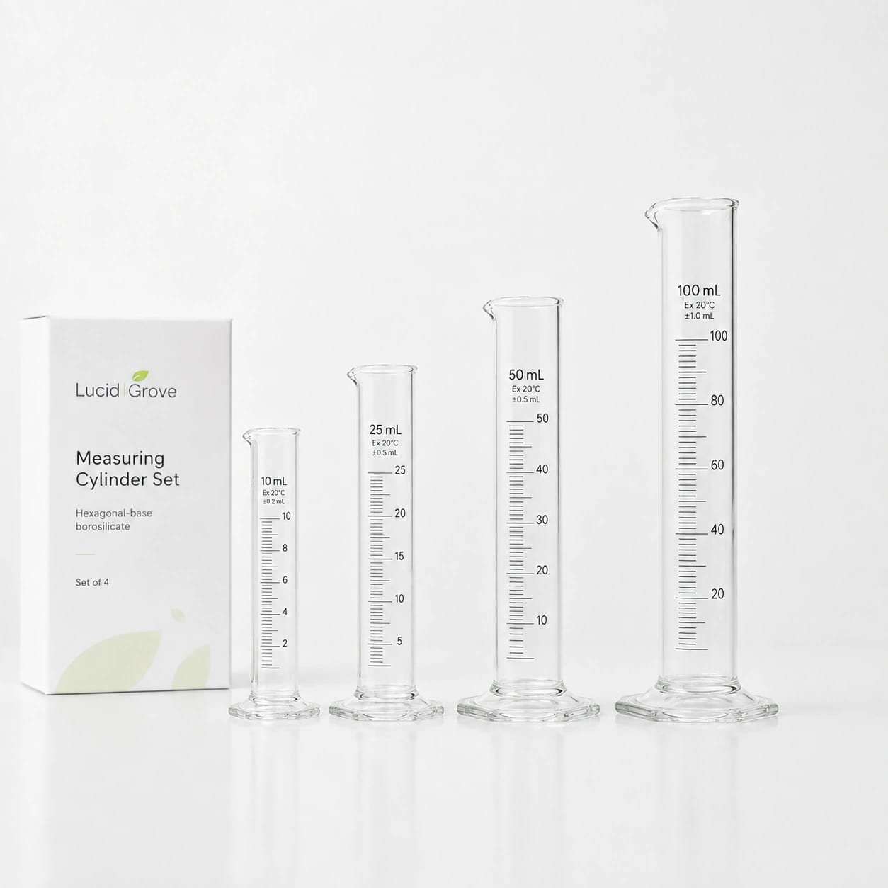 A Lucid Grove set of four graduated borosilicate measuring cylinders with hexagonal bases, beside the box.